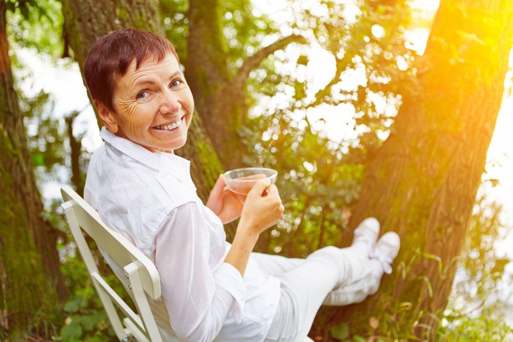 Elderly woman having her tea outdoors