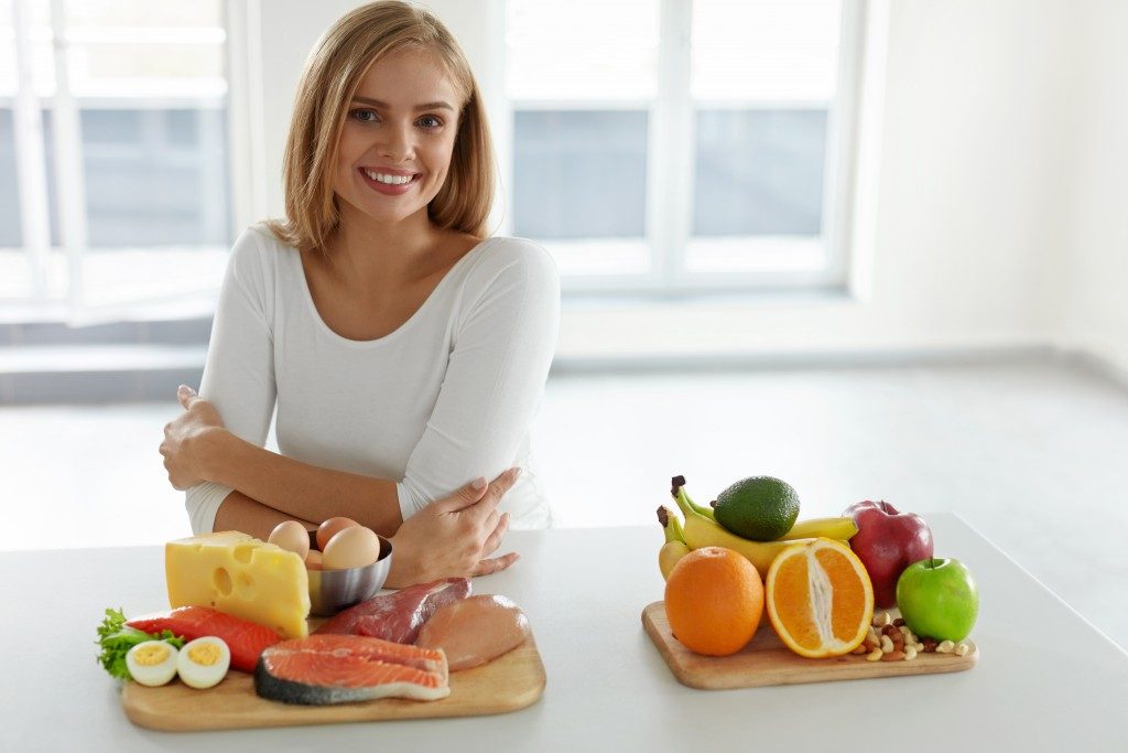 woman with fresh fruits and ingredients for her diet
