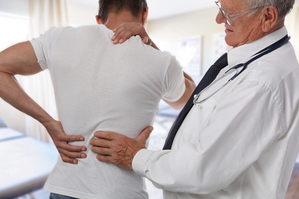 Doctor examining a patient with back pain