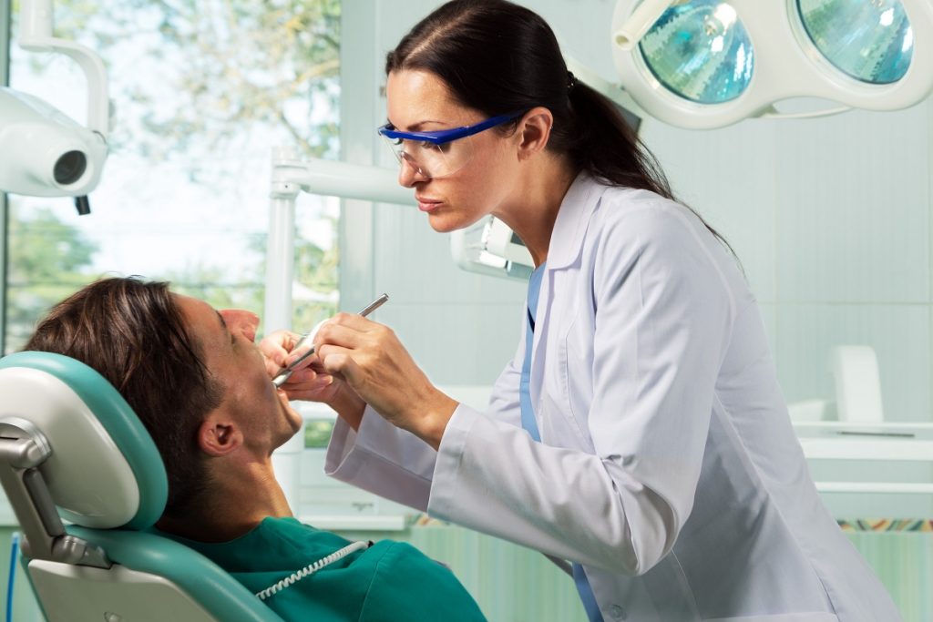 Dentist checking the teeth of her patient