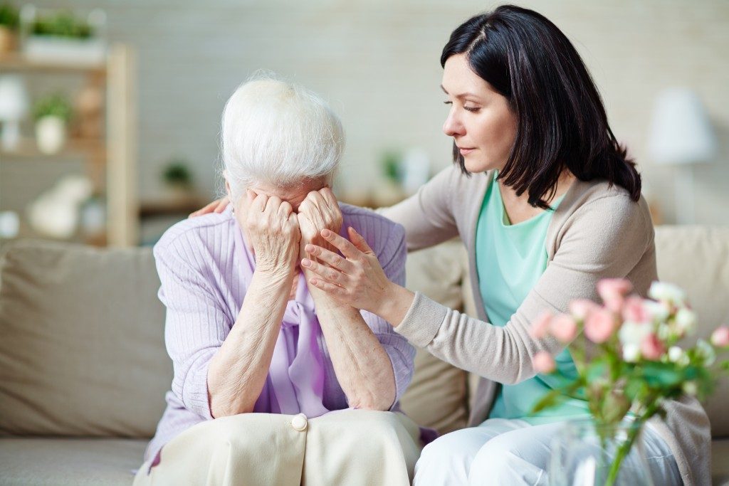 daughter consoling her upset elder mom