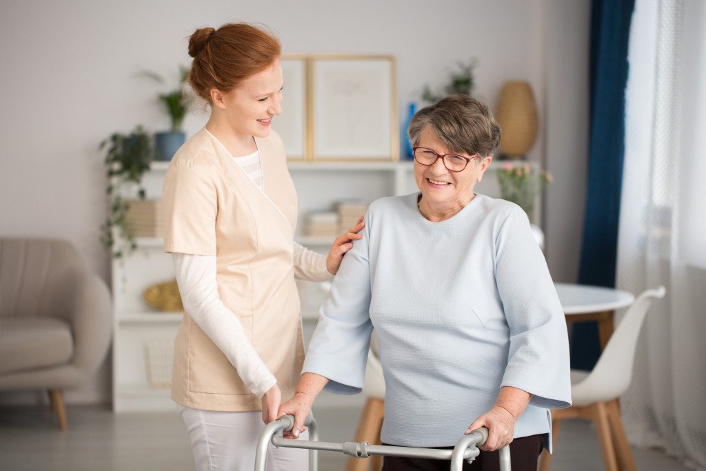 Caretaker assisting elderly to walk