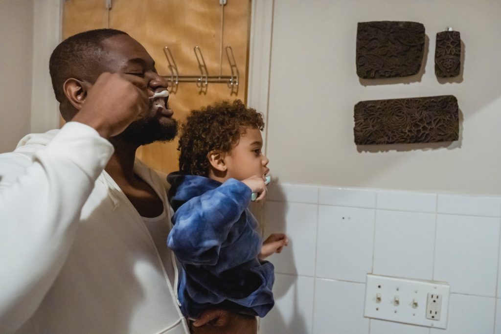 father and child brushing teeth