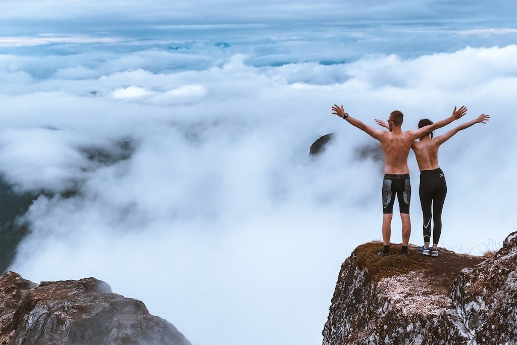 Scenic Photo of People Standing on Cliff
