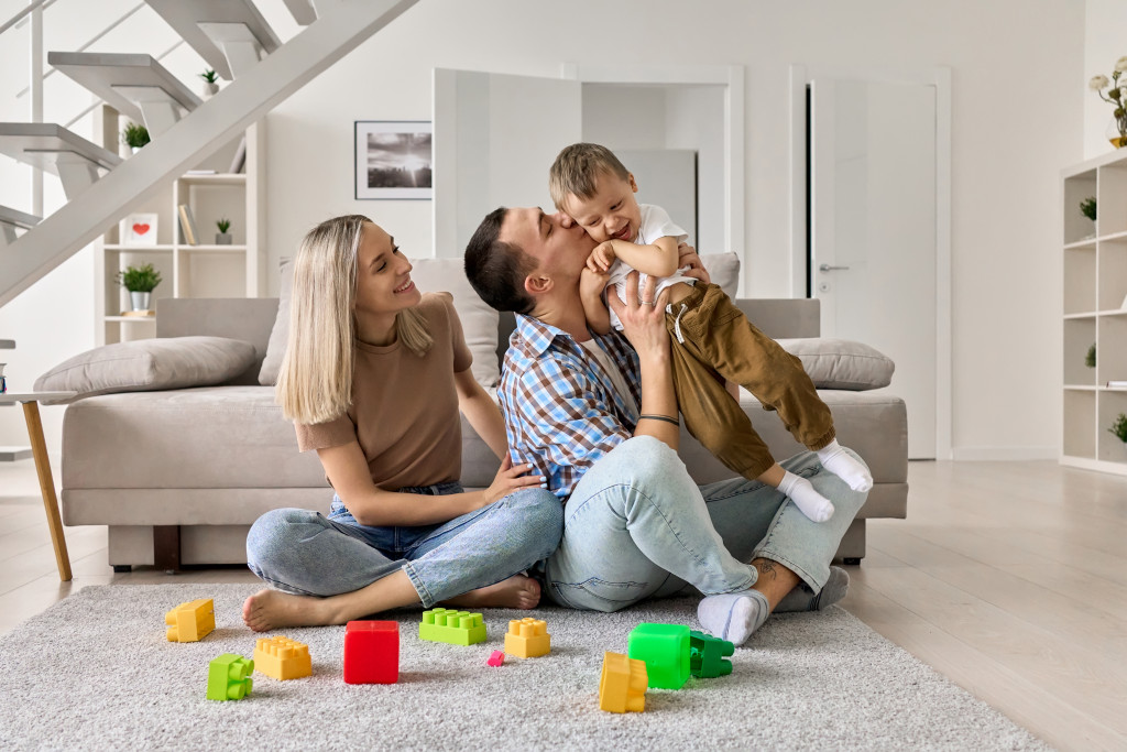 Young parents playing with their young kid in the living room