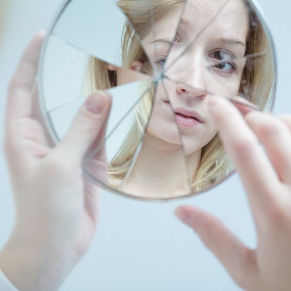 woman holding a broken mirror