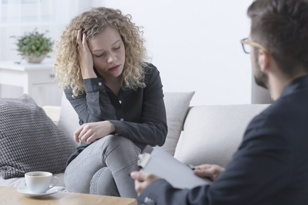 young girl speaking with therapist